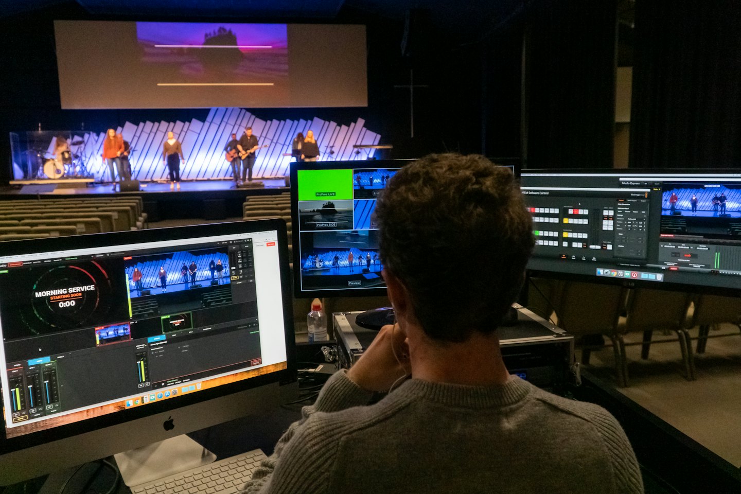 Technician monitors stage performance control software and video feeds.